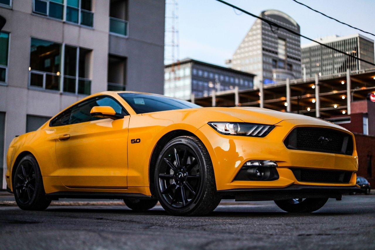 Yellow modern performance coupe parked on a city street.